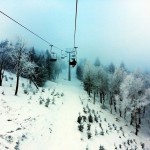 Nebliger Tagim Skigebiet, Sessllift fährt, einsamer Skifahrer, Winter ist hier, Schnee liegt darunter, kaum ein Skifahrer, Grau, Melankolik